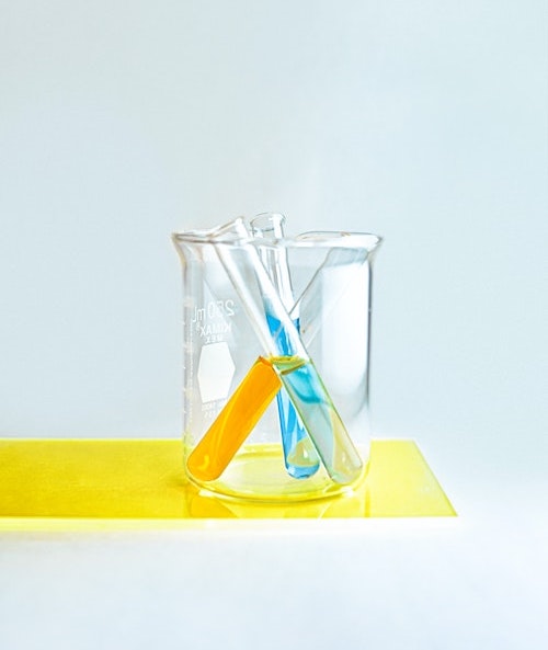 A glass beaker holding three test tubes.