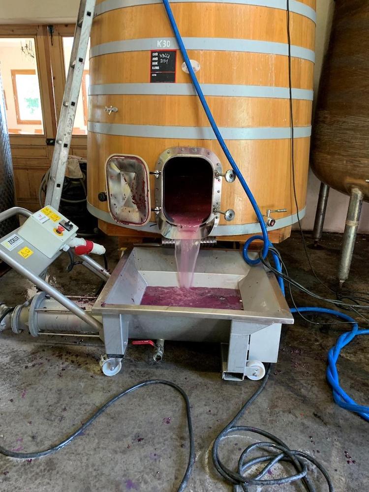 Magenta juice pouring out of a barrel.