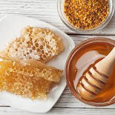 Honey in a glass bowl and honeycomb on a plate.