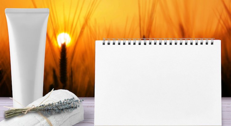 A tube of sunscreen, a towelette, and a desk calendar backlit by the setting sun.